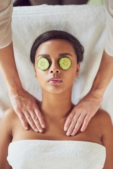 Getting the royal pampering she deserves. a young woman with cucumber slices over her eyes receiving a beauty treatment at a spa.