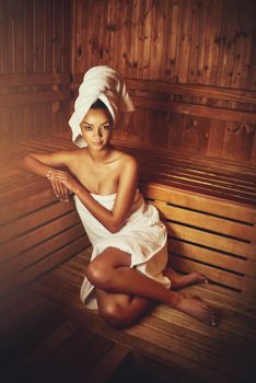 No stress today...Full length portrait of a young woman relaxing in the sauna at a spa.