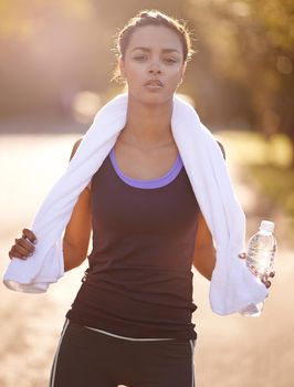 Believe you can and youre halfway there. a woman holding a towel around her neck after exercising.