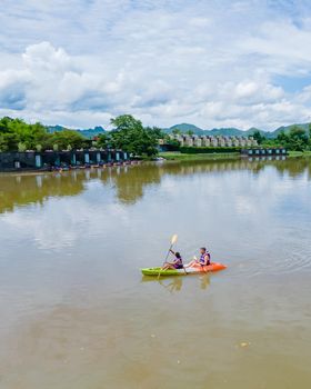 Couple men and women kayaking in the River Kwai Thailand
