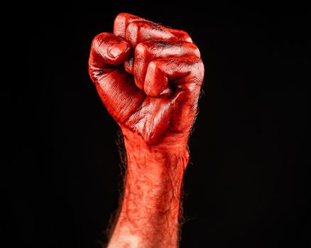 Bloody male fist on a black background.