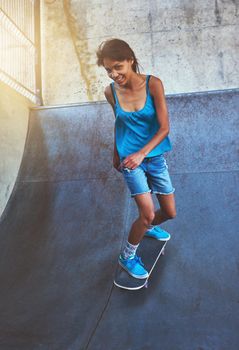 She believed she could so she did. a young woman doing tricks on her skateboard at the skatepark.