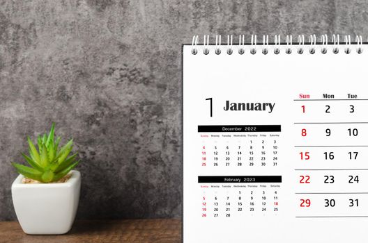 The January 2023 Monthly desk calendar for 2023 on wooden background.