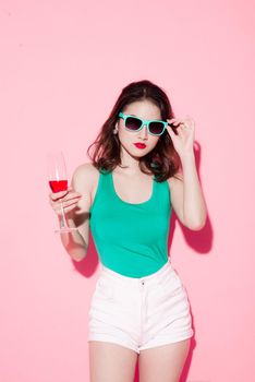 Cheerful young asian woman raising glass of wine