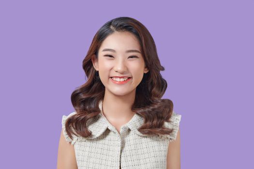 Portrait of happy and positive woman close eyes, smiling carefree on purple background.