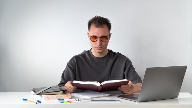 Student with a textbook at a desk on a white background