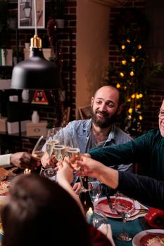 People clinking glasses with sparkling wine, proposing christmas toast