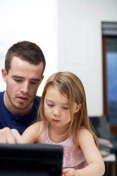 Sharing the wonders of technology with her. A father teaching his daughter how to use technology.