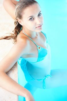 Young bikini female relaxing in a swimming pool. Sexy young female relaxing in a swimming pool.