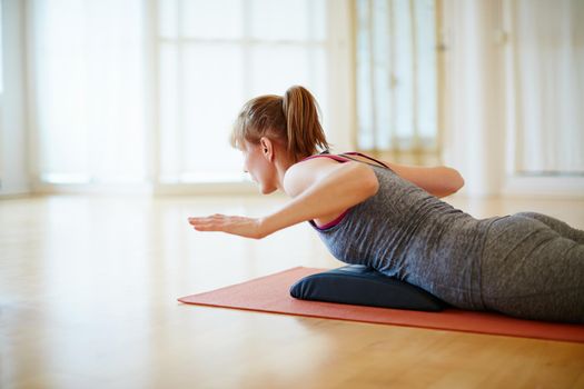 Concentrating on a healthier lifestyle. a woman doing a yoga workout indoors.