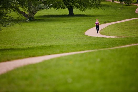 The perfect place for a jog. a woman jogging along a foothpath in a park.