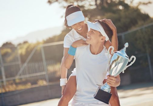 Tennis winner, sports game and team trophy for winning sport competition on court, celebrate champion success and collaboration achievement. Man and woman athlete giving piggyback after win at event