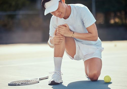 Sport, pain and tennis injury by athlete man holding knee during a competitive match at outdoor court. Professional asian tennis player suffering from hurt muscle, fitness accident while exercising