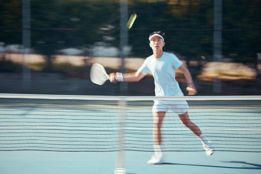 Asian tennis professional training with a racket and playing a game on court. Fit athlete running during a match and play competitive sport workout for fitness and health alone in a sports club