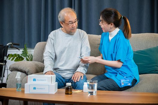 Woman nurse caregiver showing prescription drug to senior man at nursing home