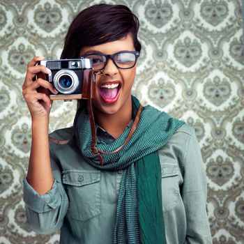 Let me capture that beauty. a young woman posing with a camera over a patterned background.