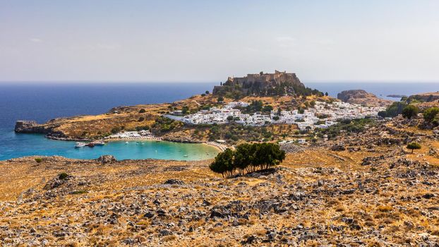 The famous and historical medieval village of Lindos on the Greek island of Rhodes with the Acropolis in the background. Lindos, Rhodes, Greece.