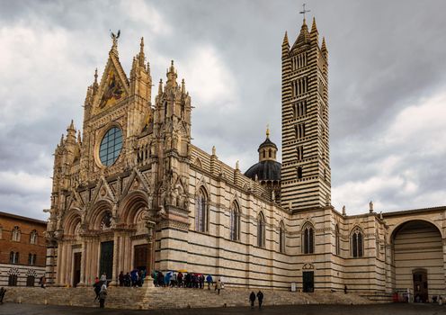 Famous Piazza del Duomo with historic Siena Cathedral, Tuscany, Italy. Siena Cathedral (Duomo di Siena) is a medieval church, now dedicated to the Assumption of Mary, Siena, Italy.