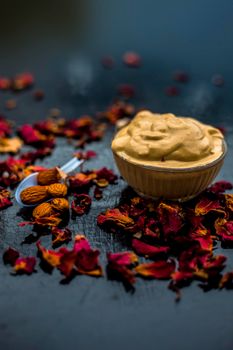 Multani mitti or fuller's earth or mulpani mitti face mask on wooden surface in glass bowl consisting of milk, almonds, and bentonite clay.For the treatment of softer skin.