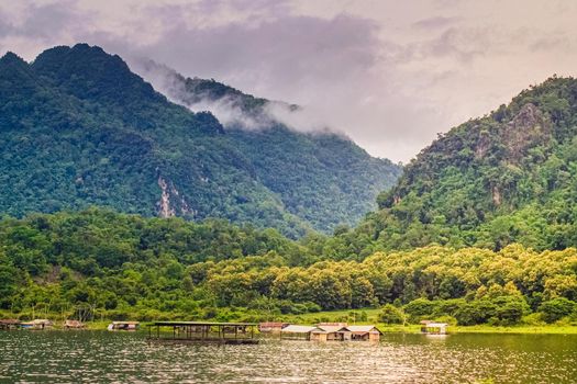 Lakeside raft houses on lake .beautiful landscape with foggy over mountains on background in Kanchanaburi Thailand