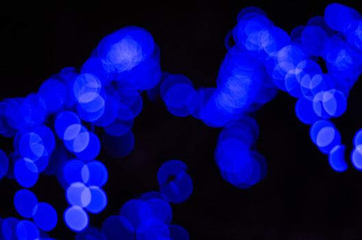 Blurred photo shows Illumination bulbs with blue colours.
