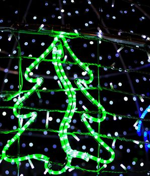 Glowing electric illumination of Christmas tree shaped lights.