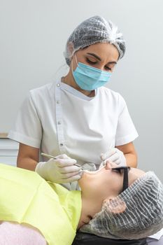 Dentist Examining Patient's Mouth with dental mirror In Clinic