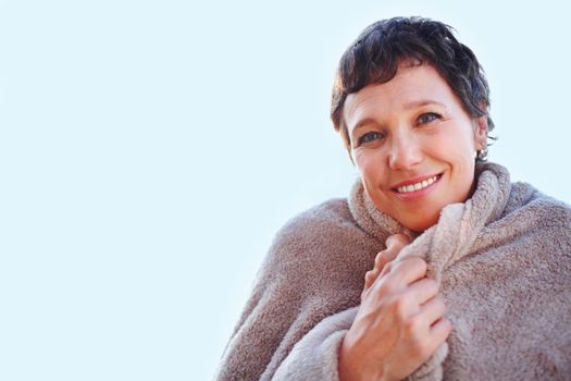 Get cozy. Portrait of beautiful mature woman smiling wearing woolen shawl.