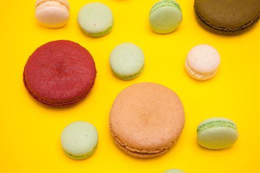 Delicious french macaroons flavors over yellow background
