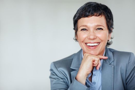 Mature business woman. Portrait of happy mature business woman smiling over plain background.