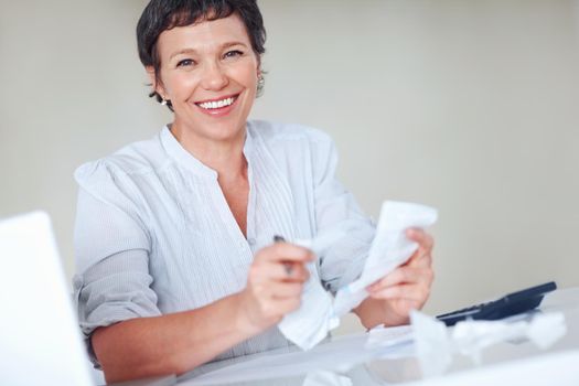 Happy taxes. Portrait smiling mature business woman calculating taxes in office.