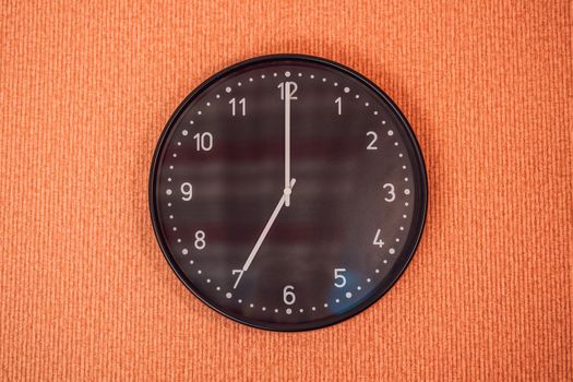 Classic black and white analog clock on red background at One o'clock with copy space