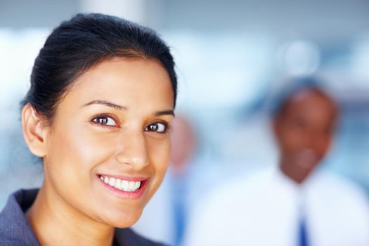 Successful business woman with blur colleague in background. Detail shot of a successful business woman with blur colleague in background.