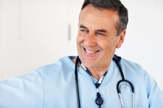 An experienced, mature doctor smiling against white. Closeup portrait of experienced, mature doctor smiling against white.