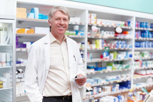 Pharmacist at work. Portrait of mature pharmacist holding a prescription in drugstore.