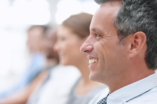 Learning business tips - Conference. Closeup of a businessman smiling as he attends a conference - Copyspace.