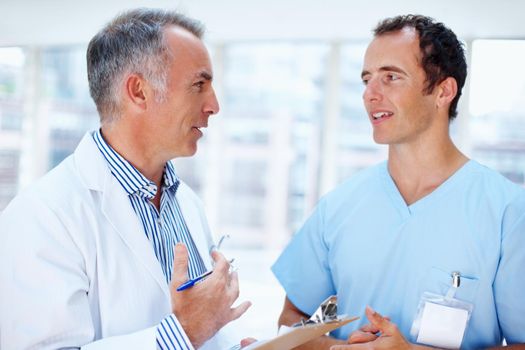 Doctor and resident discussing options. Two men in the healthcare profession having discussion.