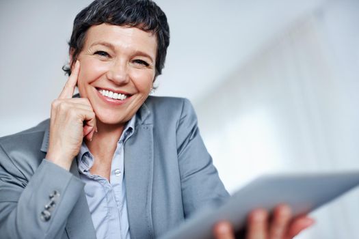 Business woman using digital tablet. Portrait of cheerful mature business woman using tablet PC in office.