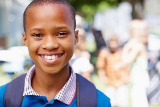 Im ready for a new school year. Confident african-american boy smiling at you with schoolmates in the background - copyspace.