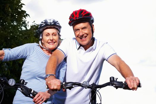 Smiling mature couple with bicycles on a sunny day. Portrait of a smiling mature couple with bicycles on a sunny day.