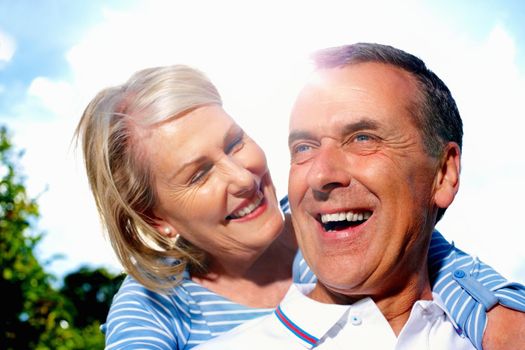 Cheerful man and woman spending time together against sky. Closeup portrait of a cheerful senior man and woman spending time together against sky.