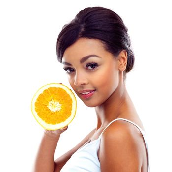 Get your daily dose of vitamins. A young woman in gymwear holding an orange and smiling at the camera.