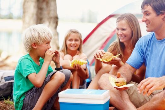 Family having breakfast while camping. Family of four having breakfast on a camping holiday.