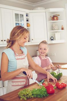 I cant wait to taste this salad. Young mother and her daughter making a salad together.