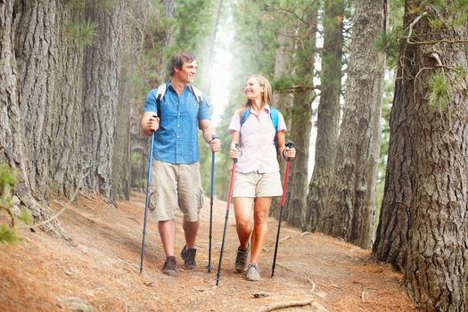 Couple hiking in the woods and looking at each other. Full length of couple hiking in the woods and looking at each other.