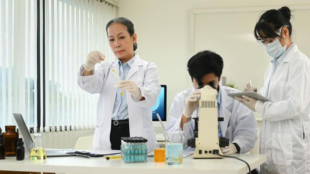 Professional scientist team conducting experiment in laboratory. Medicine and science research concepts