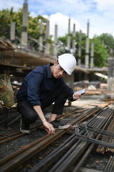 Civil engineer in had hart inspecting industrial building construction site
