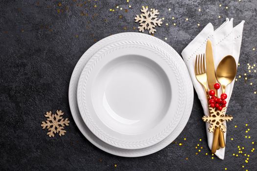 Christmas or new year table setting with golden cutlery 