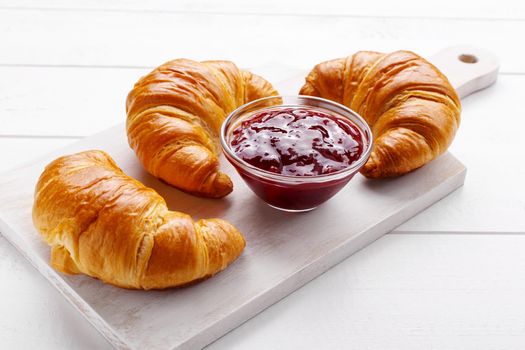 Traditional french croissant and strawberry jam