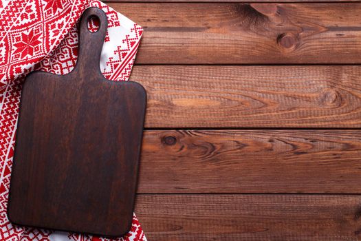 Brown wooden cutting board and red table cloth